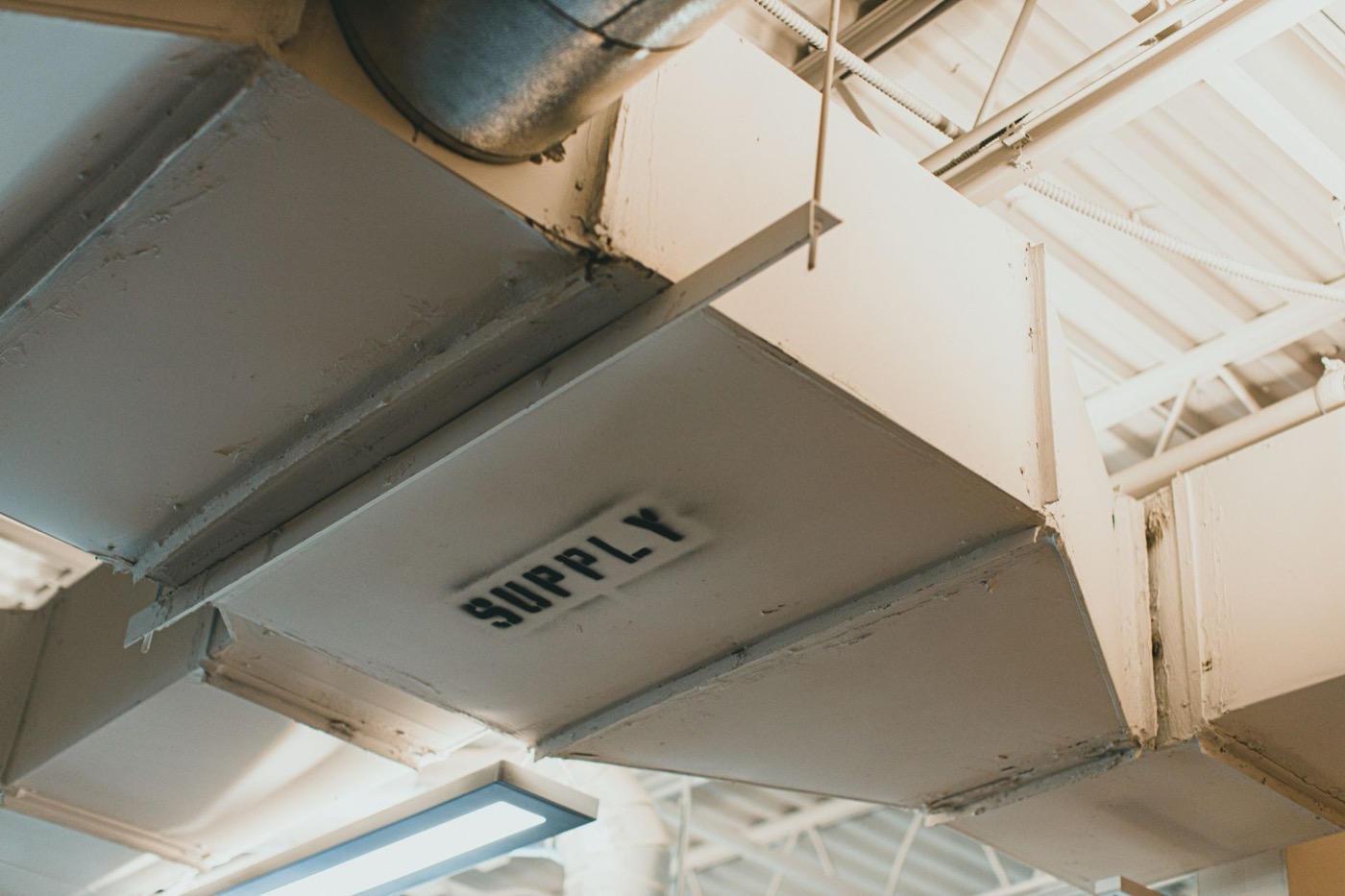 Sheet metal supply ductwork running through an unfinished ceiling